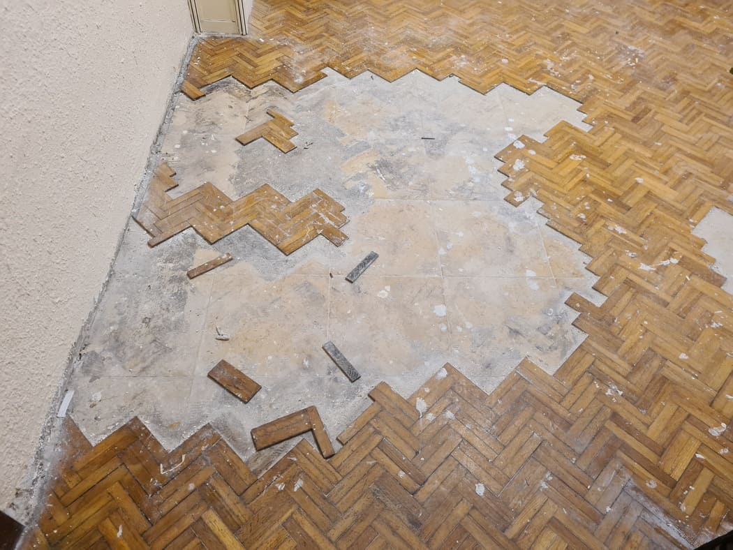 Estado del parquet afectado por la humedad antes de la restauración