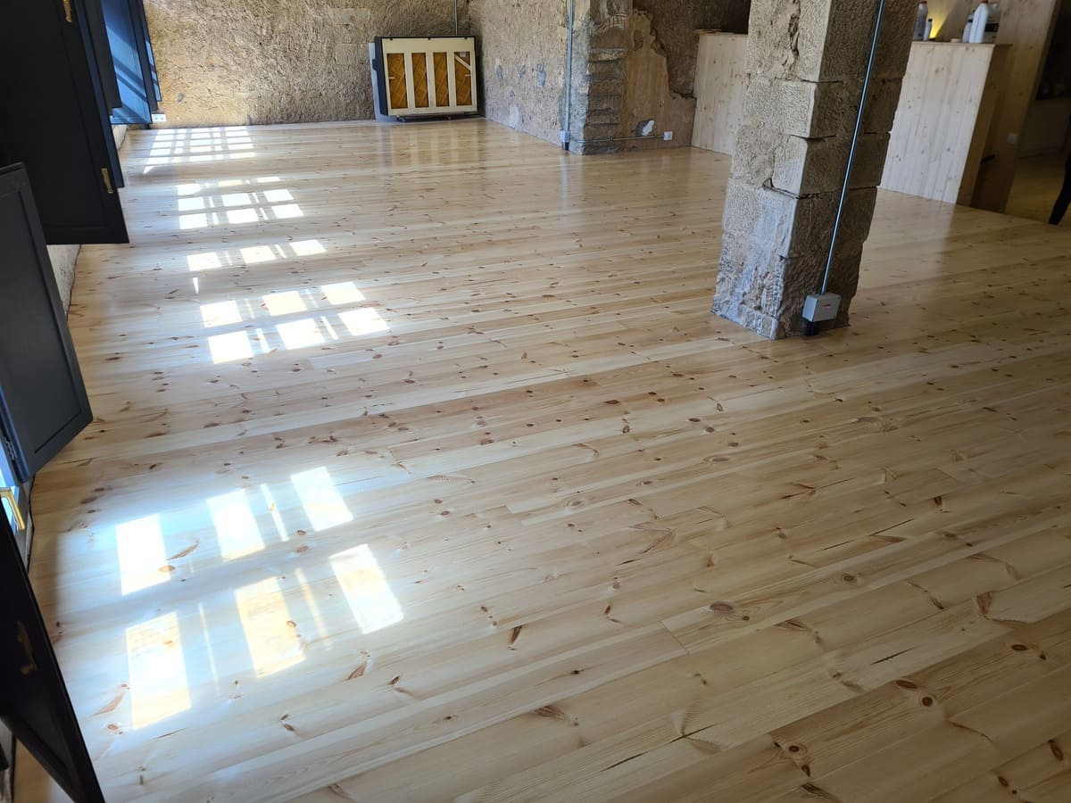 Detalle del suelo de pino pulido y barnizado en el Salón de la casa -Andreu Parquets