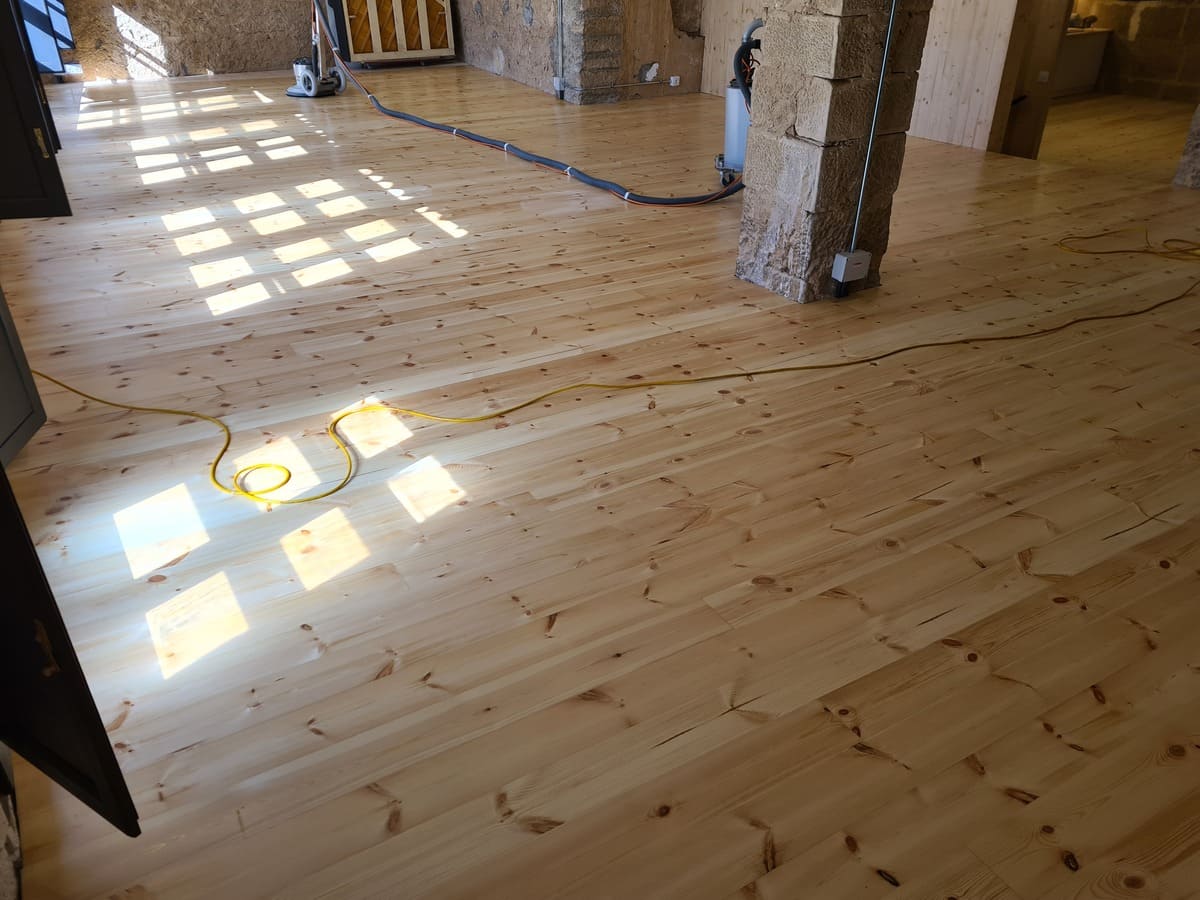 Detalle del suelo de pino pulido y barnizado en el Salón de la casa- Andreu Parquets