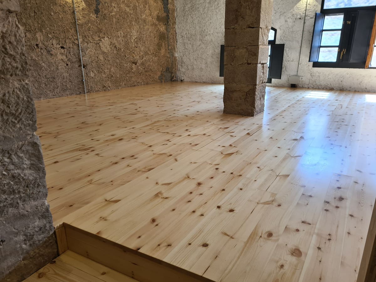 Detalle del suelo de pino pulido y barnizado en el Salón de la casa - Andreu Parquets El Soleras