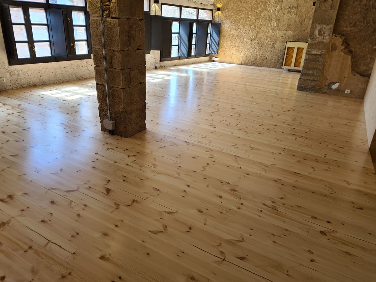 Detalle del suelo de pino pulido y barnizado en el Salón de la casa - Andreu Parquets