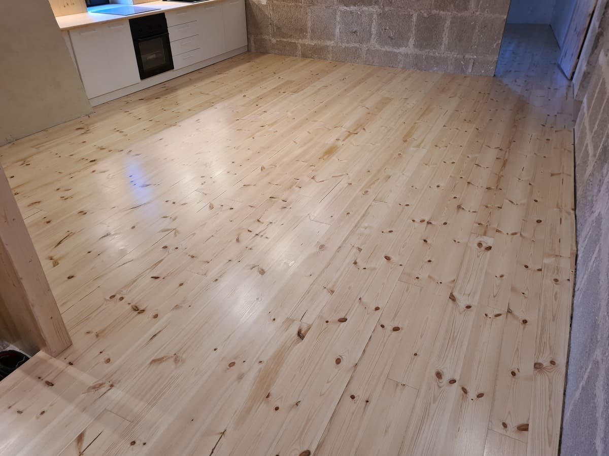 Detalle del suelo de pino pulido y barnizado en la cocina de la casa - Andreu Parquets Lleida