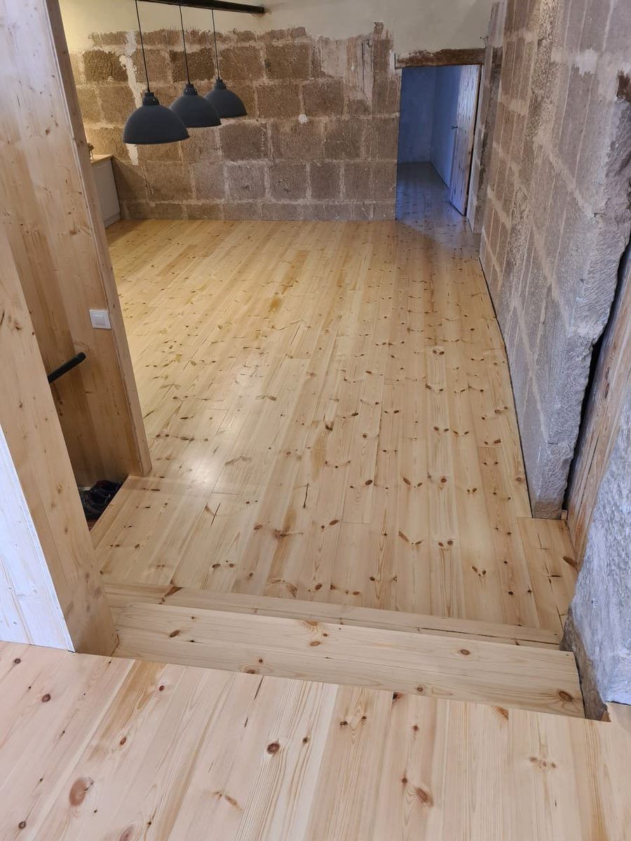 Detalle del suelo de pino pulido y barnizado en la cocina de la casa- Andreu Parquets