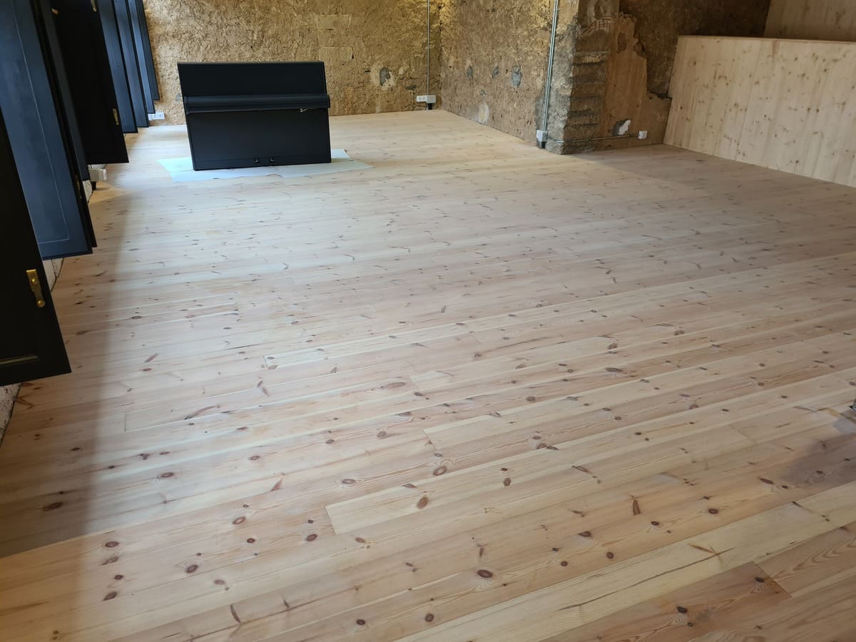 Estado del suelo de madera de Pino en el comedor antes de pulir y barnizar - Andreu Parquets Lleida