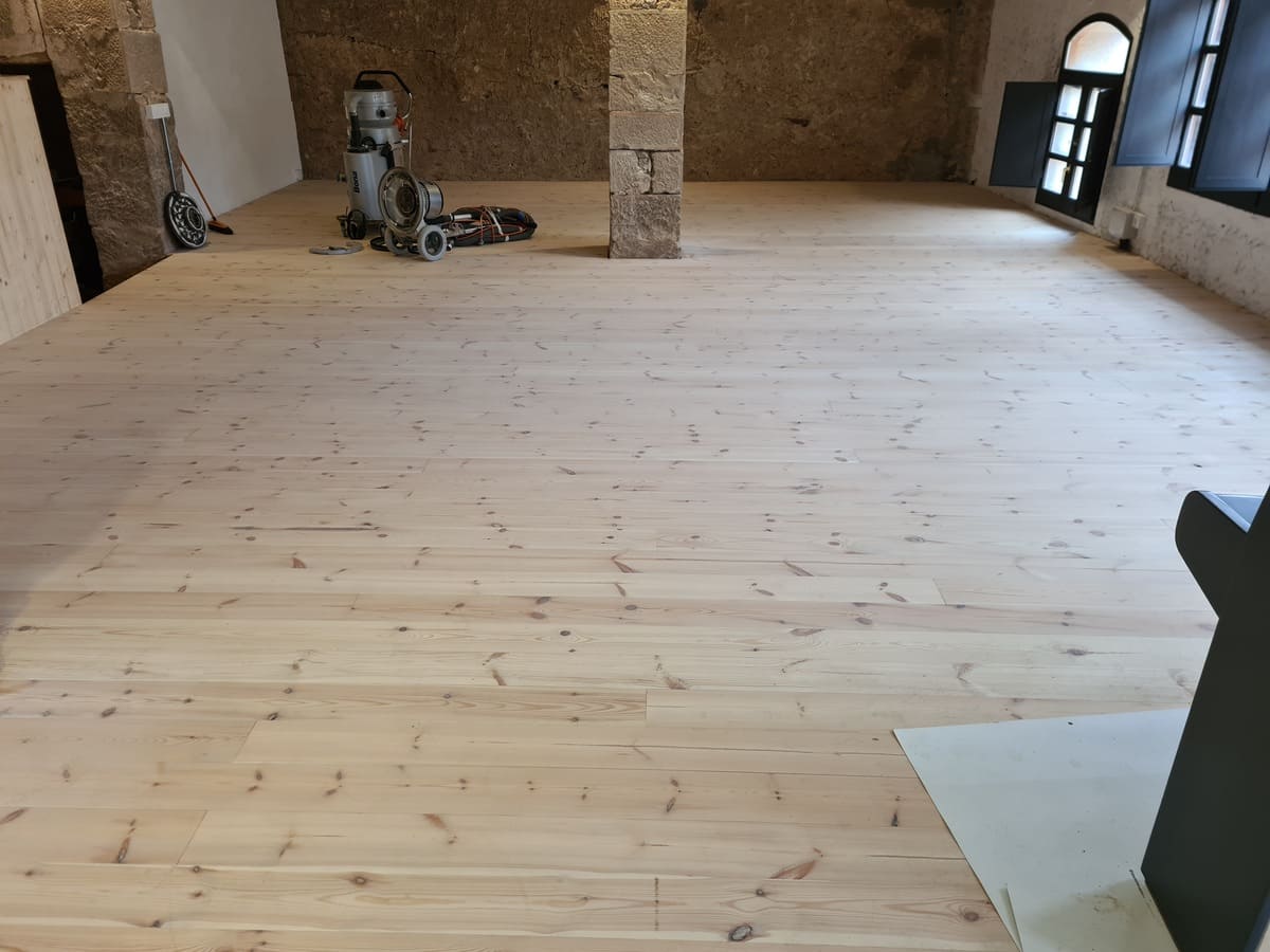 Estado del suelo de madera de Pino en el comedor antes de pulir y barnizar -Andreu Parquets en el Soleras